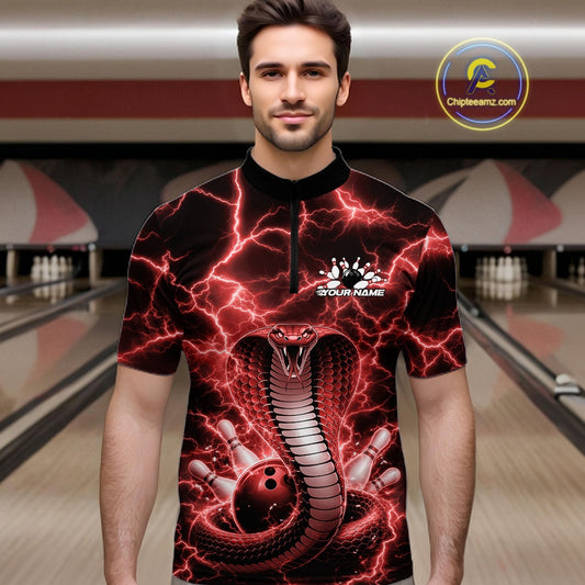 Male model in a bowling lane wearing a quarter-zip with red cobra artwork and a lightning background.