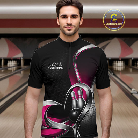 Male model in a bowling lane wearing a black and pink quarter zip shirt with honeycomb texture and a heart-framed bowling strike graphic.