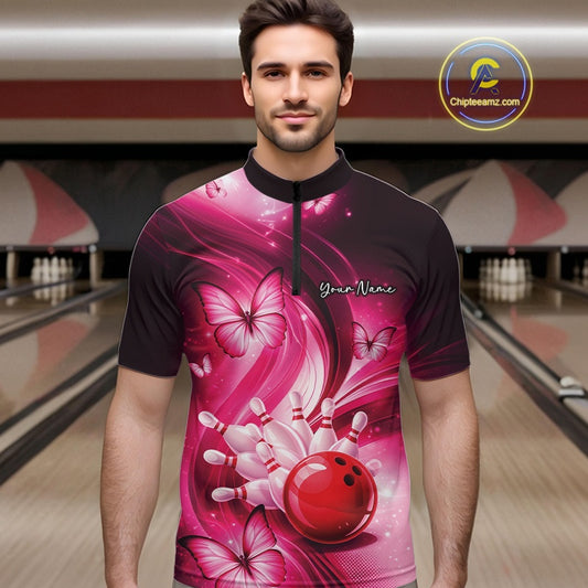 Male model wearing a pink bowling quarter-zip at the bowling lane with bowling-themed artwork and butterflies.