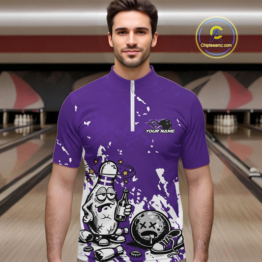 Male model in a bowling lane wearing a purple and white quarter-zip shirt, splatter-style humorous bowling pin illustration with beer bottle and ball.