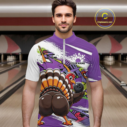 Front view of a male model wearing a purple custom quarter zip bowling shirt with a funny graffiti turkey holding a bowling ball, paint splatter accents in a bowling alley.