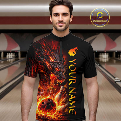 Man wearing a black bowling shirt with a dragon design in a bowling alley.