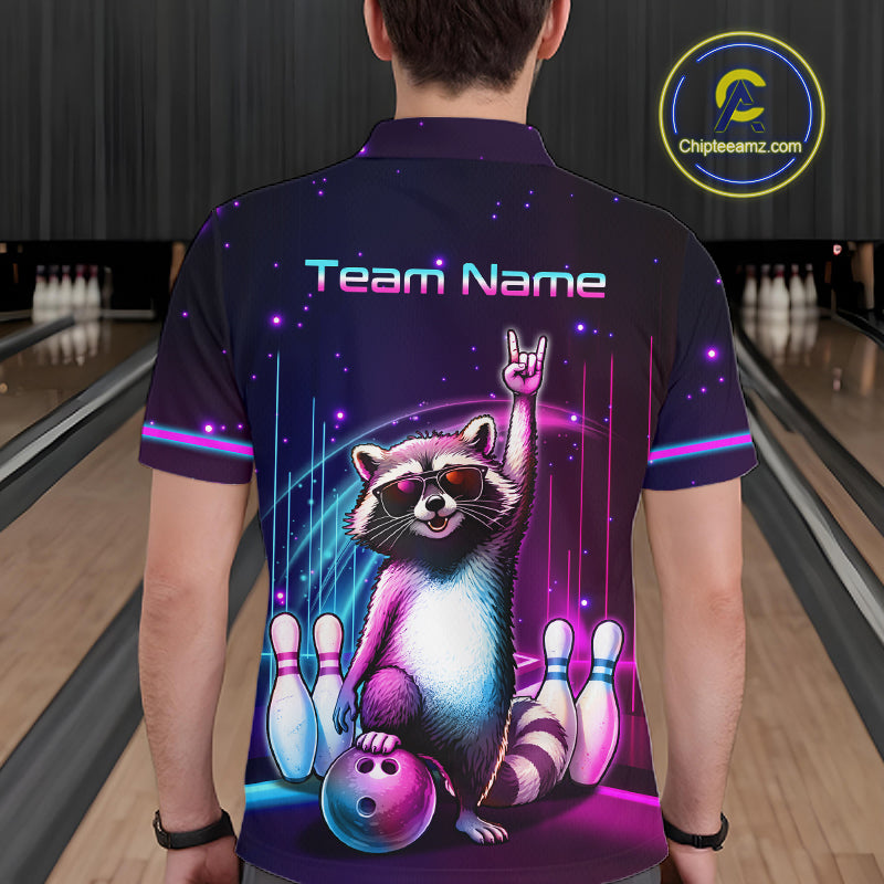 A person viewed from behind wearing a short-sleeve collared shirt in a bowling alley. The shirt has a dark purple and black space-themed graphic with neon pink and blue accents, featuring a raccoon holding a bowling ball with bowling pins around it and the text 'Team Name' across the upper back.