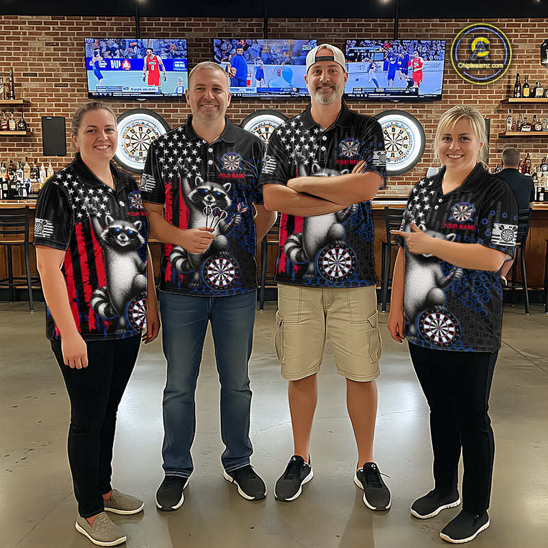 Four people standing together in a bar wearing matching black short-sleeve polo shirts with a graphic design featuring a raccoon, stars, and red and white vertical stripes. The background shows a brick wall, bar shelves, and mounted sports screens.