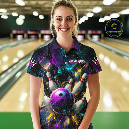 A woman stands in a bowling alley wearing a short-sleeve collared shirt with a vivid bowling-themed graphic print featuring a purple bowling ball, pins, and neon cosmic colors. The shirt has a placeholder name on the chest 