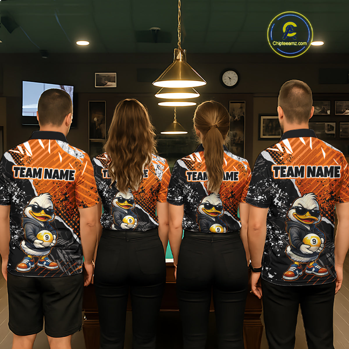 Four people standing with their backs to the camera in a dimly lit indoor room, wearing matching custom-printed athletic jerseys. The jerseys feature a cartoon duck mascot in sunglasses holding ball 9, set against orange and black splatter patterns, with 'TEAM NAME' printed across the upper back.