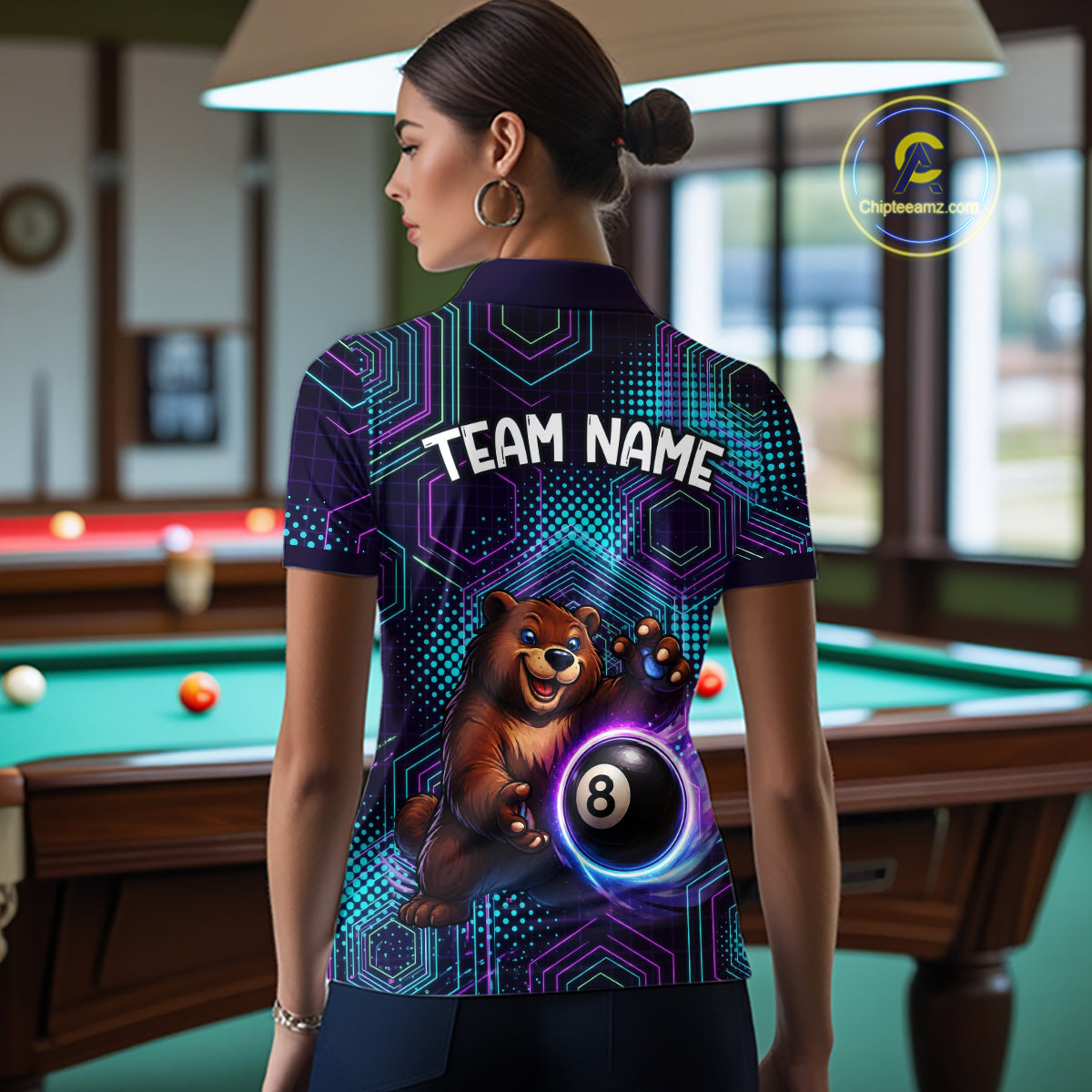 Person wearing a shirt with a bear holding a pool ball design in a billiards room.