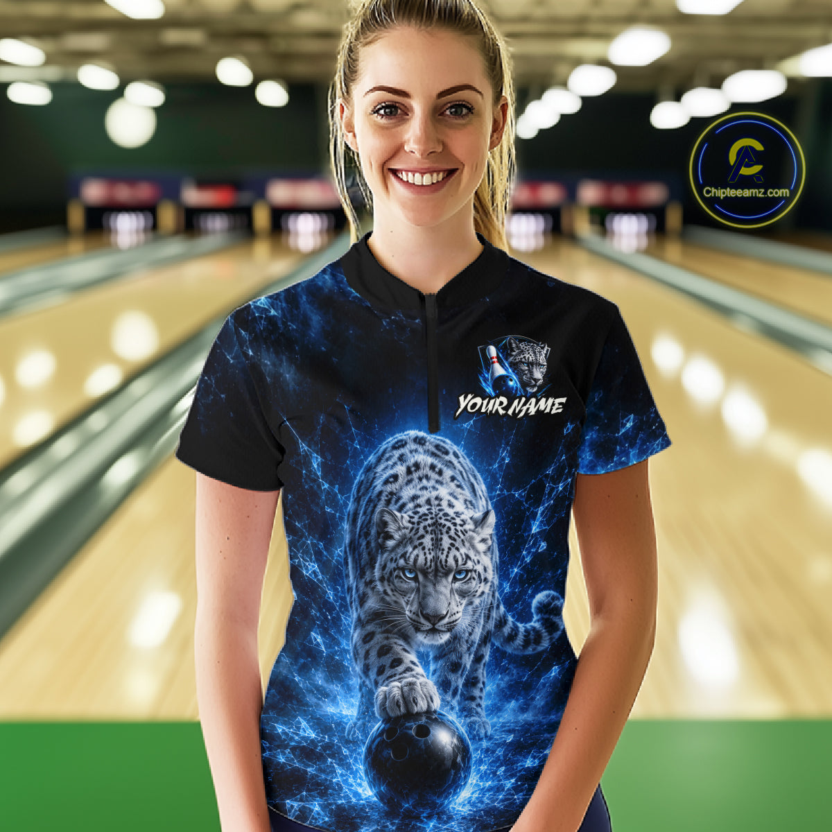 Woman wearing a black shirt with a blue and white design of a leopard and text in a bowling alley.