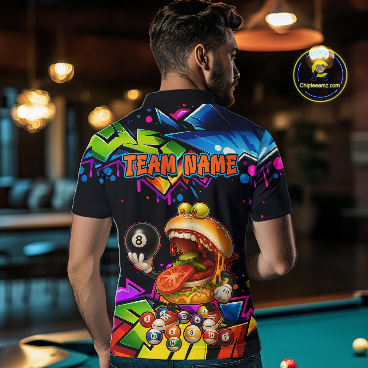 Person wearing a colorful shirt with a graphic design and 'Team Name' text, standing in a bar setting.