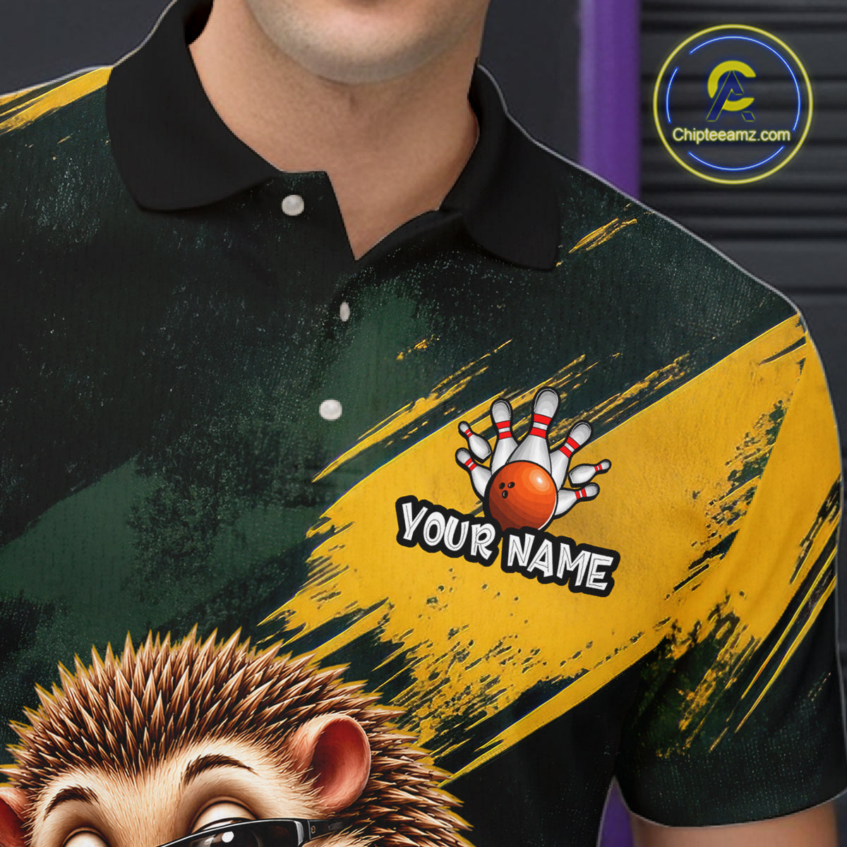 A close-up of a person wearing a short-sleeve polo shirt with a custom graphic design. The shirt features a black and yellow brush-stroke pattern, a bowling pin and orange bowling ball graphic with the text 'YOUR NAME', and a cartoon hedgehog illustration at the bottom.