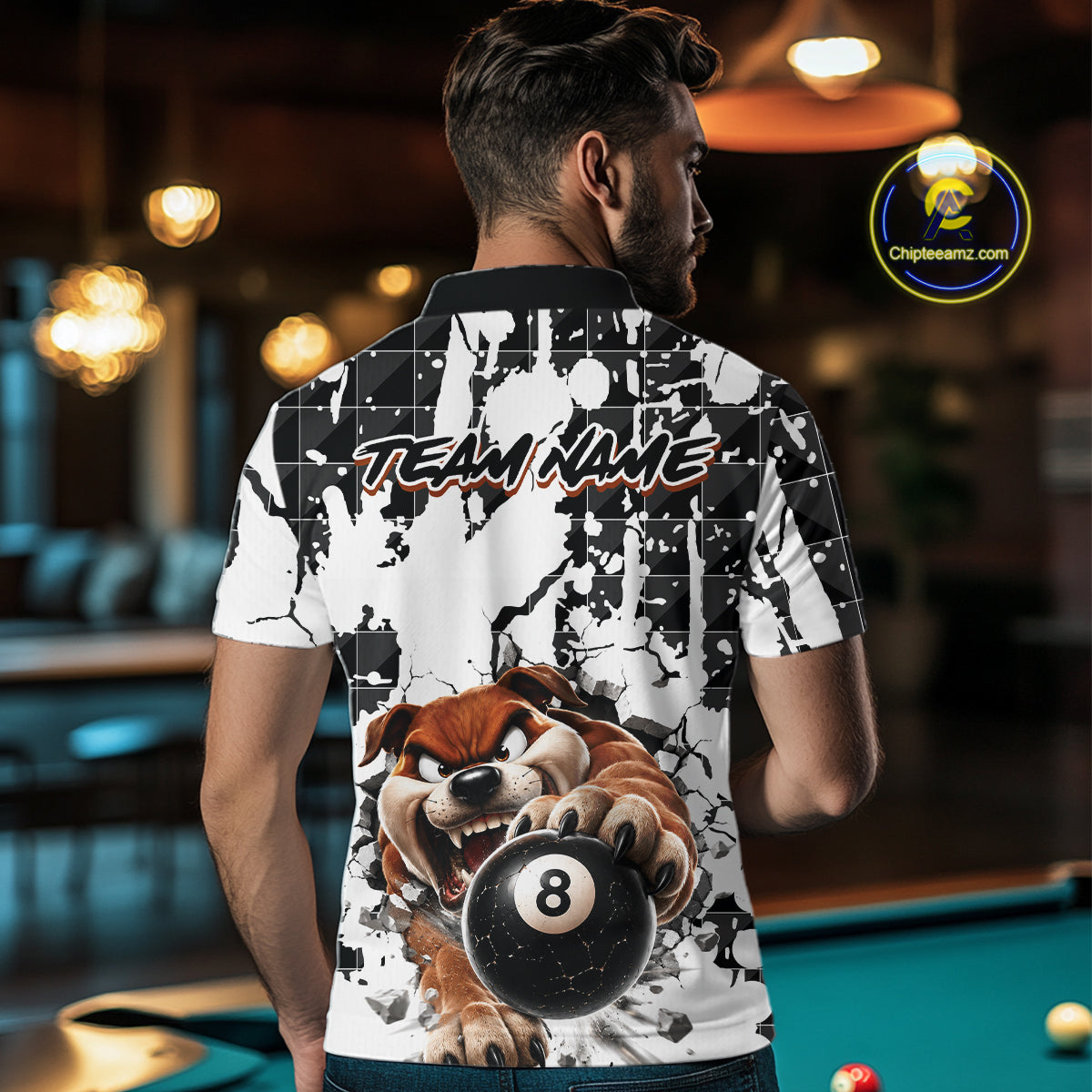 Man wearing a shirt with a dog holding a pool ball design in a bar setting.