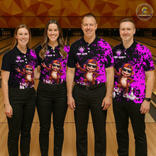 Load image into Gallery viewer, Four people standing in a bowling alley wearing matching black polo shirts with a bright pink and purple splatter design, featuring a cartoon monkey wearing sunglasses.