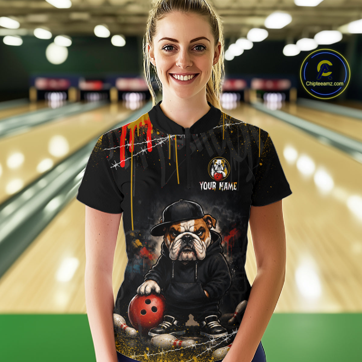 A woman wearing custom black bulldog bowling quarter-zip shirt front view featuring a fierce cartoon mascot, bowling ball and paint drip effect, displaying Your Name, at the bowling alley