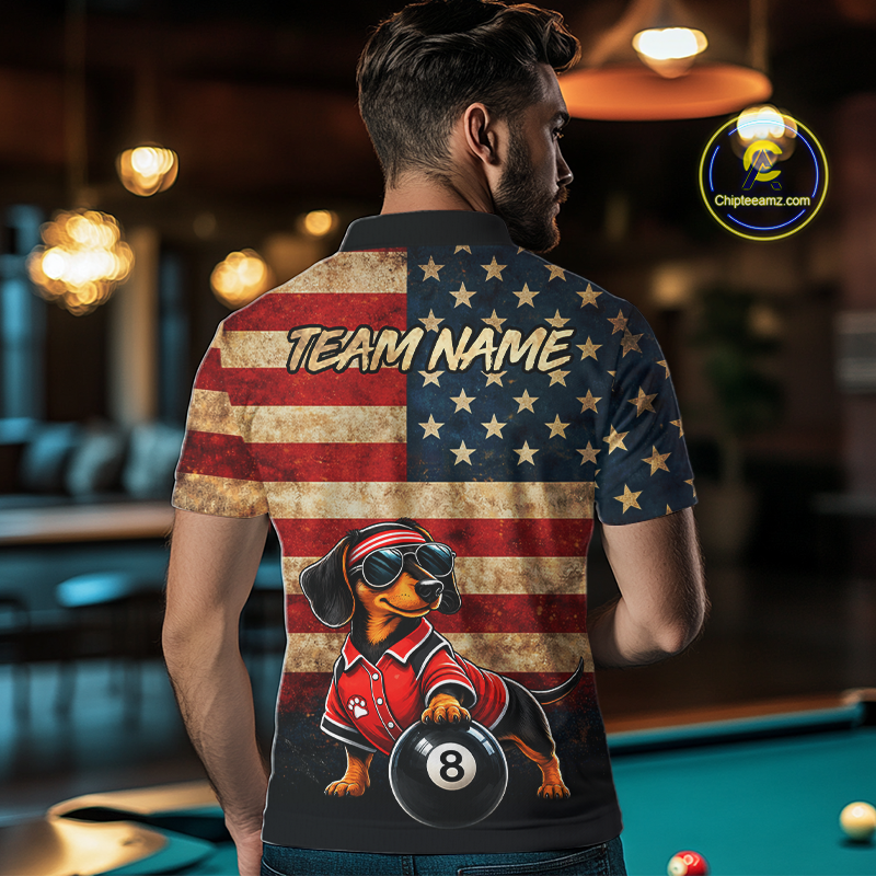 A man viewed from behind wearing a custom short-sleeve polo shirt with a patriotic dachshund design. The back of the shirt features a distressed American flag pattern with the text 'TEAM NAME' and a graphic of a dachshund wearing a red racing suit and holding an 8-ball.