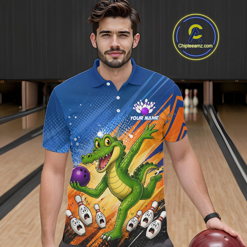A man wearing a custom bowling-themed short-sleeve polo shirt with a cartoon alligator graphic, standing in a bowling alley holding a bowling ball. The shirt features a blue and orange striped background with a green alligator catching a purple bowling ball.