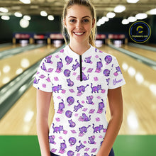 Load image into Gallery viewer, Woman wearing a white shirt with purple cat pattern in a bowling alley.