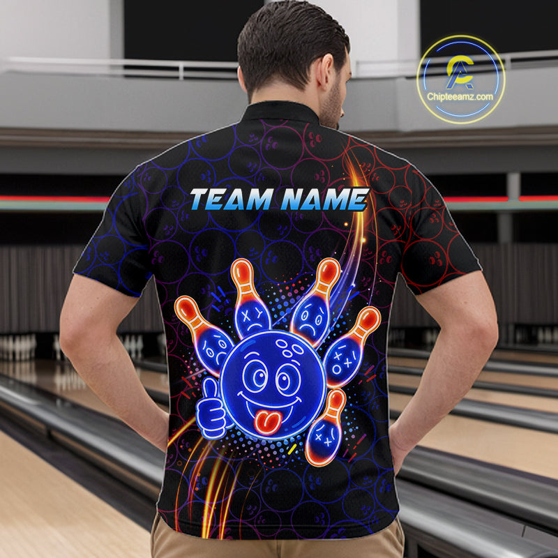 Man standing in a bowling alley wearing a black neon-style bowling quarter zip shirt with a glowing blue cartoon bowling ball mascot, fiery orange pin graphics, and custom team name text.