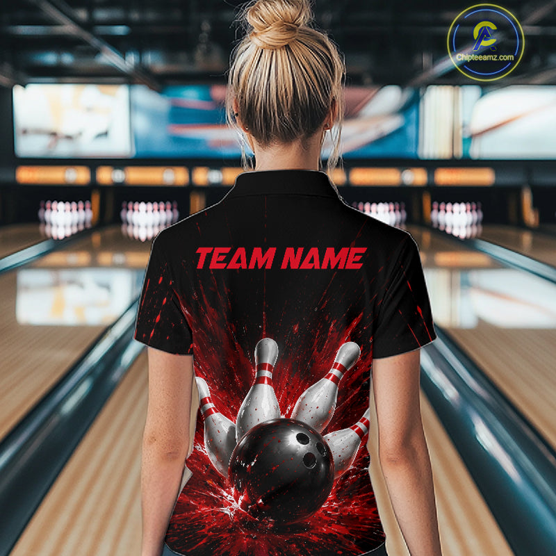 Woman wearing a black bowling quarter zip shirt with dramatic red splatter graphics, a large black bowling ball, and flying pins, plus custom team name text.