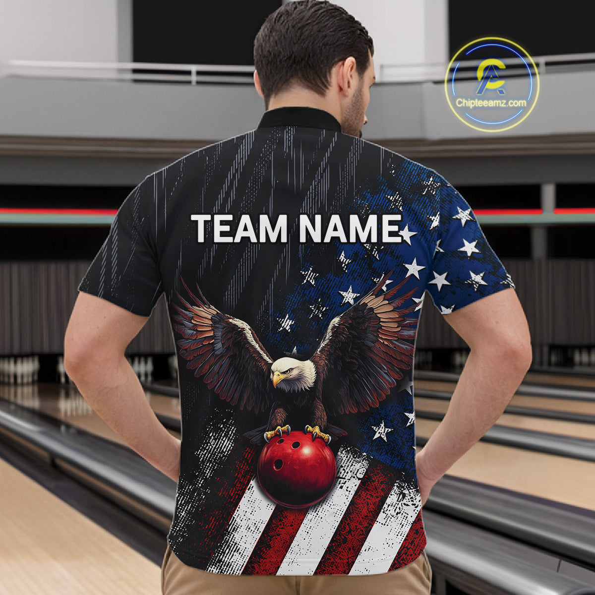 A man viewed from behind wearing a bowling shirt with a patriotic American flag design, featuring a bald eagle holding a red bowling ball, stars, stripes, and the text 'TEAM NAME'. The background shows bowling lanes in a bowling alley.