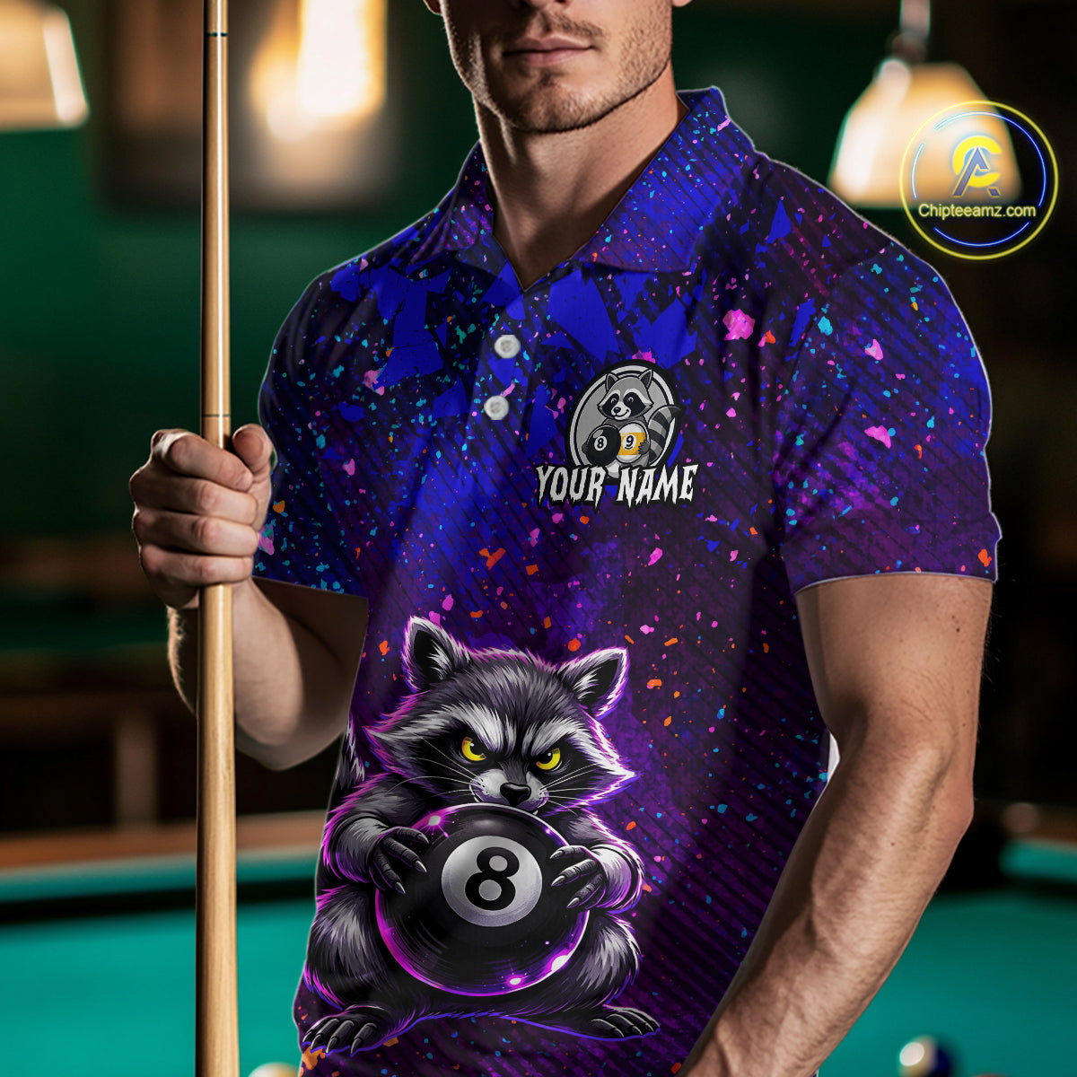 Man wearing a colorful polo shirt with a raccoon design holding a pool cue on a pool table.