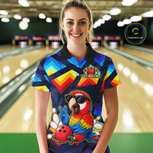 Load image into Gallery viewer, A woman stands in a bowling alley wearing a short-sleeve collared bowling shirt with a colorful geometric pattern and a large parrot graphic on the front. The shirt has a custom name patch on the chest and a circular 'Chippewazinc.