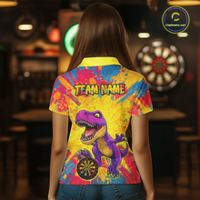 Load image into Gallery viewer, Women wearing darts polo shirt featuring a purple dinosaur holding a dartboard within a bright colorful paint splatter background.