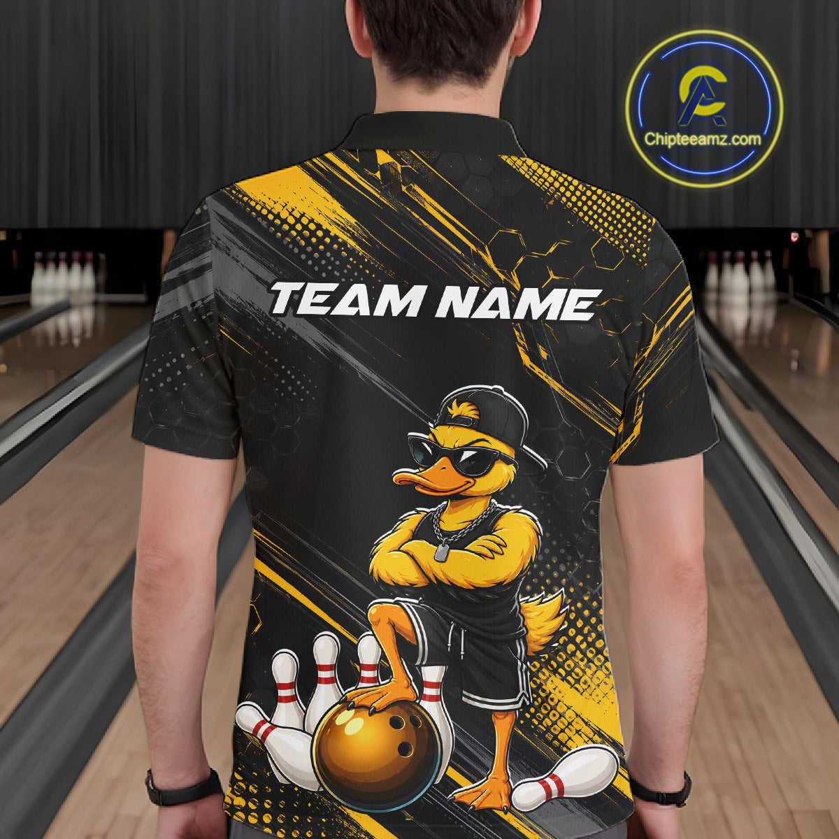 Person wearing a bowling-themed shirt with a duck graphic in a bowling alley.
