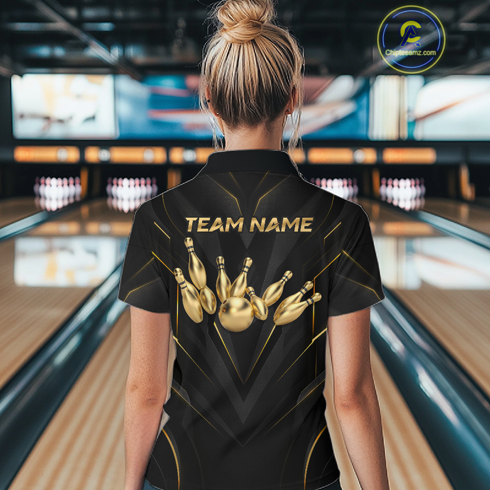 Woman wearing a black bowling shirt with gold pins design and 'TEAM NAME' text in a bowling alley.