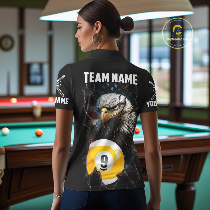 Woman wearing a black shirt with an american flag eagle 9 ball and pool ball design, standing in a bar.
