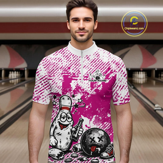 Male model in a bowling lane wearing a pink and white quarter-zip shirt, playful drunk bowling pin artwork with beer bottle and bowling ball.