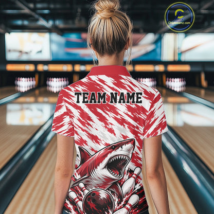Person wearing a red and white shirt with a shark design and 'TEAM NAME' text in a bowling alley.