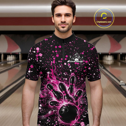 Male model wearing a black bowling quarter-zip shirt at the bowling lane with pink paint splatter accents and bowling strike graphics.