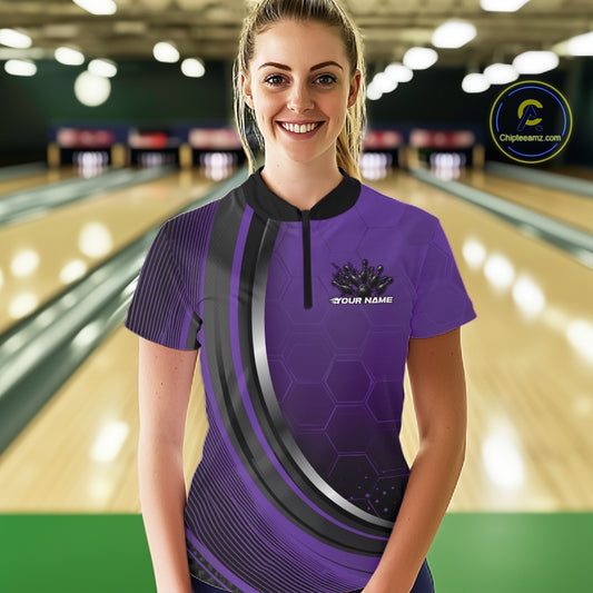 Front view of a female model wearing a black and purple bowling quarter zip featuring honeycomb accents and a flaming bowling ball hitting the pins.