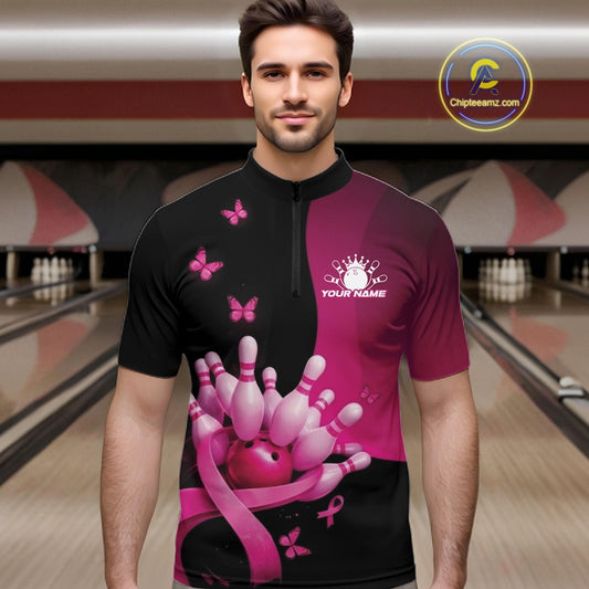Male model in a bowling alley wearing a black and pink quarter zip shirt with breast cancer awareness ribbons, butterflies, and bowling-themed graphics.