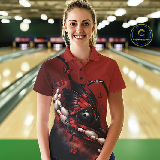 Female model wearing a red and black bowling polo shirt at a bowling lane with butterfly artwork, bowling ball graphics, and pins.