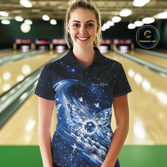 Female model at a bowling lane wearing a blue bowling polo shirt with luminous butterfly wings surrounding a bowling ball on the front.