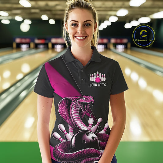 Female model wearing a black bowling polo in a bowling center with pink cobra artwork and bowling pin graphics.