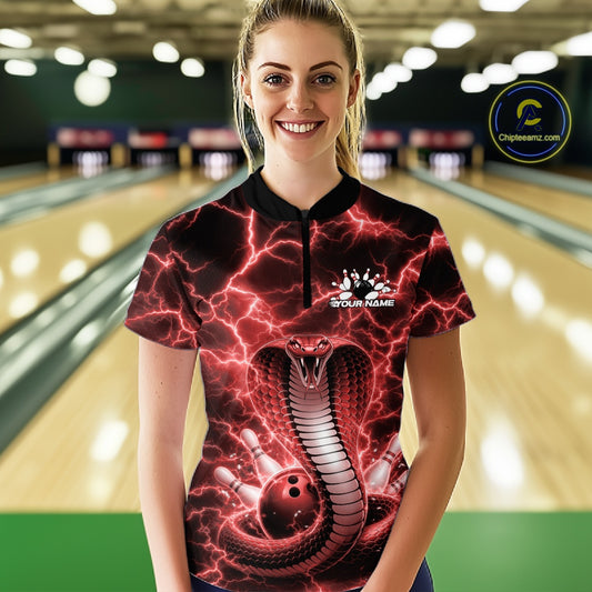 Female model wearing a bowling quarter-zip in a bowling center featuring red cobra artwork and lightning-themed graphics.