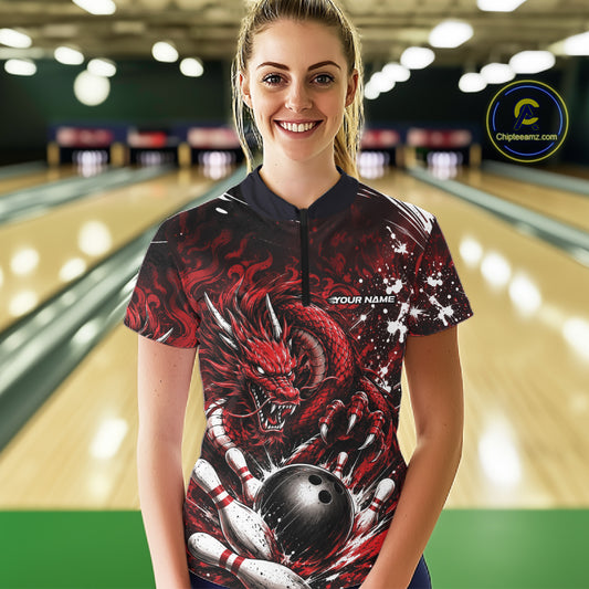 Person wearing a red dragon-themed bowling shirt in a bowling alley.