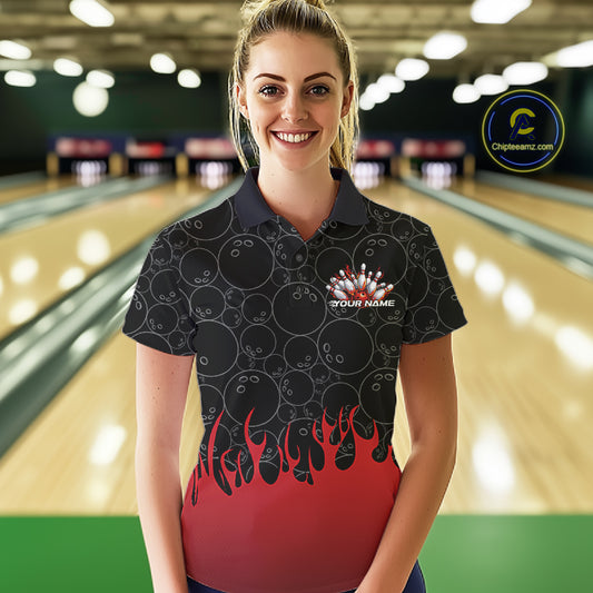 Front view of a female model in a bowling lane wearing a black polo shirt with vibrant red flames and bowling ball pattern and dynamic flaming bowling design.