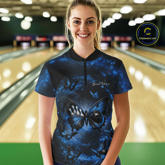 Female model at a bowling lane wearing a quarter-zip bowling shirt featuring a blue and black butterfly artwork with a bowling ball body.