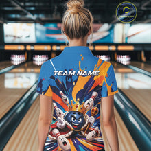 Load image into Gallery viewer, Back view of a female model wearing a bowling polo shirt featuring a crowned cartoon bowling ball with a royal scepter, cheering animated bowling pins, and colorful paint splashes in a bowling lane.