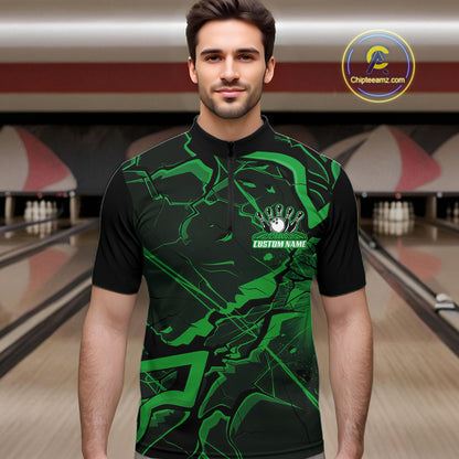 Male model wearing a black and green quarter-zip in a bowling lane with sharp cracked geometric artwork.