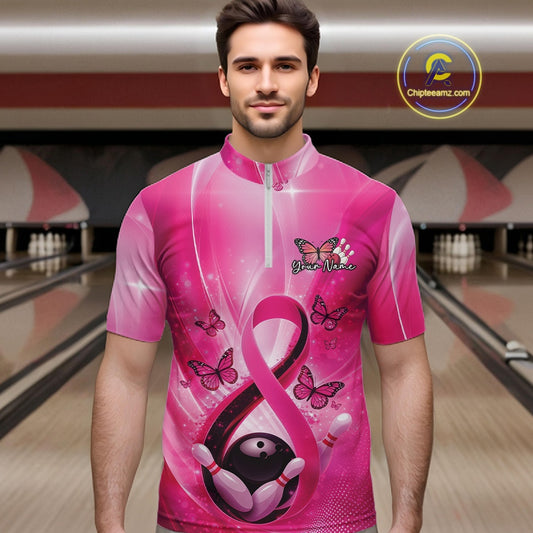 Male model wearing a bowling quarter-zip at the bowling lane displaying pink ribbon, butterfly, and bowling-themed graphics.