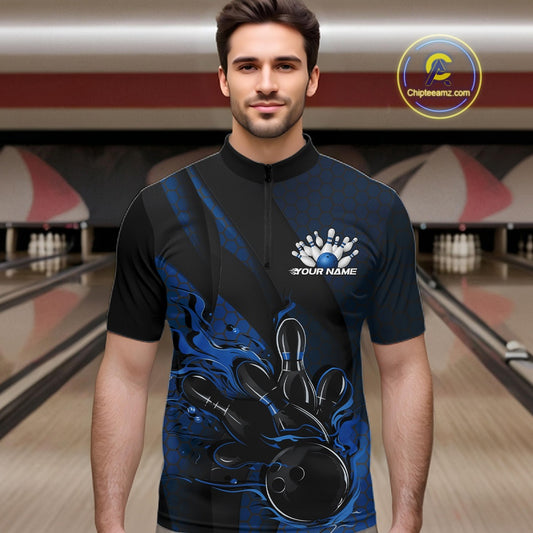 Male model at a bowling lane wearing a black and blue bowling quarter-zip shirt with fiery bowling strike artwork, hexagonal details, and diagonal striping.