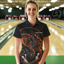 Load image into Gallery viewer, Front view of a female model in a bowling alley wearing an orange custom bowling polo shirt featuring an aggressive dragon with flames in a dynamic and energetic design.
