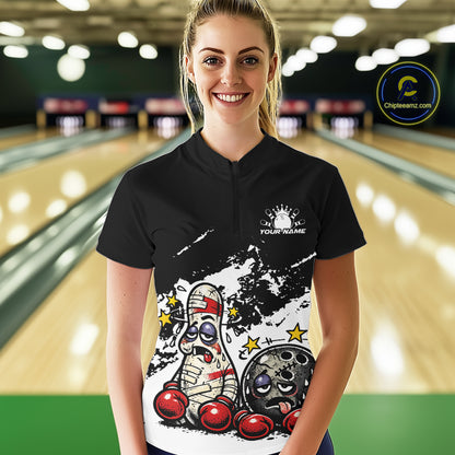Female model in a bowling lane wearing a black and white quarter-zip shirt, cartoon boxing bowling ball and pin design with bold contrast.