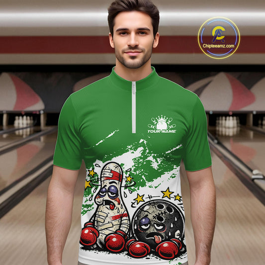 Male model at a bowling lane wearing a green and white quarter-zip shirt, humorous boxing bowling ball and pin artwork with playful energy.