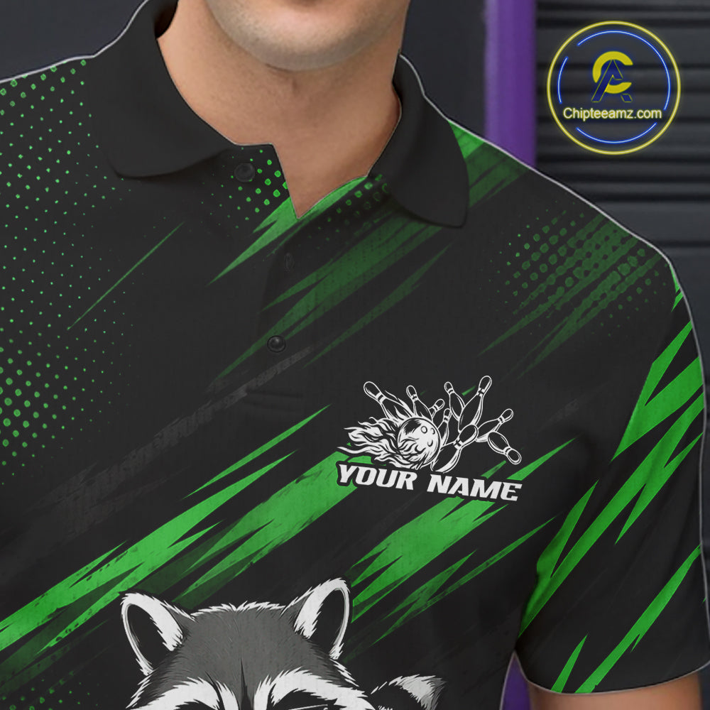 A close-up of a man wearing a black and green polo shirt with a raccoon graphic and a custom name patch on the chest. The shirt features a black collar and a pattern of green brushstrokes and halftone dots on a black background.