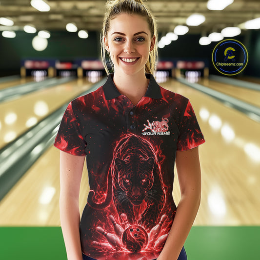 Front view of a female model in a bowling lane wearing a black polo shirt with glowing red electric panther and energetic bowling strike graphics.